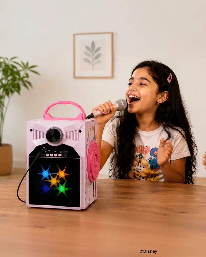 Girl singing with Disney Frozen LED karaoke Bluetooth speaker and microphone for fun music and home karaoke experience