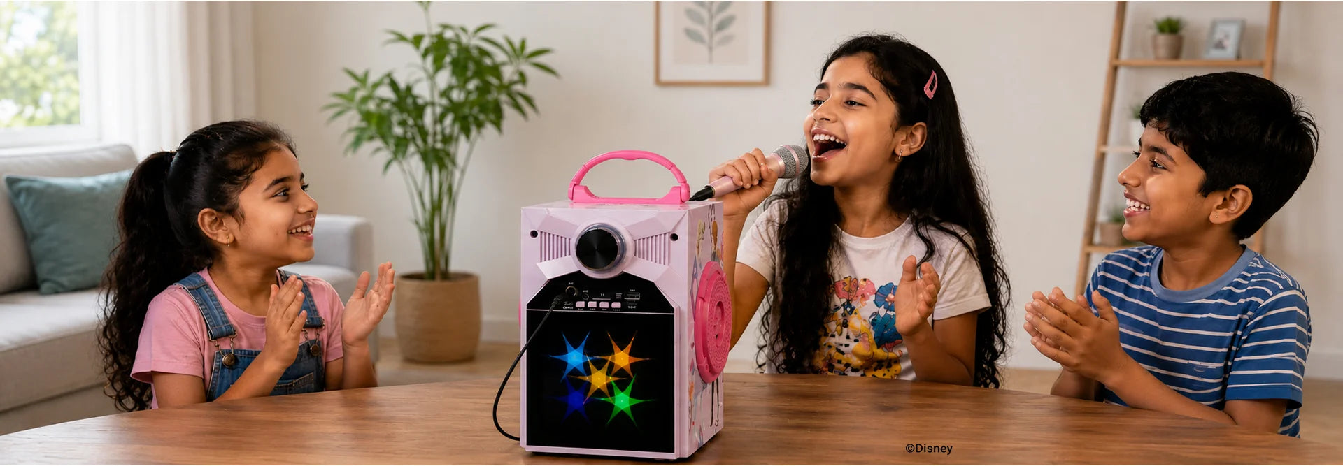 Kids enjoying Disney Frozen LED karaoke Bluetooth speaker with microphone, singing and clapping together at home
